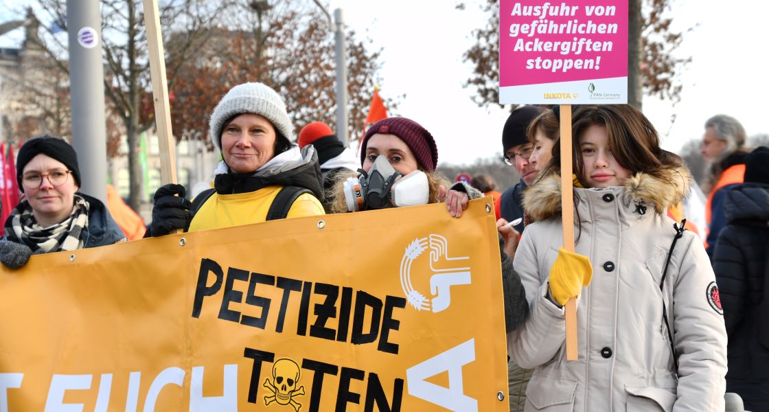 Menschen auf einer Demo am Reichstag in Berlin mit Bannern und Schildern mit der Aufschrift Pestizide töten
