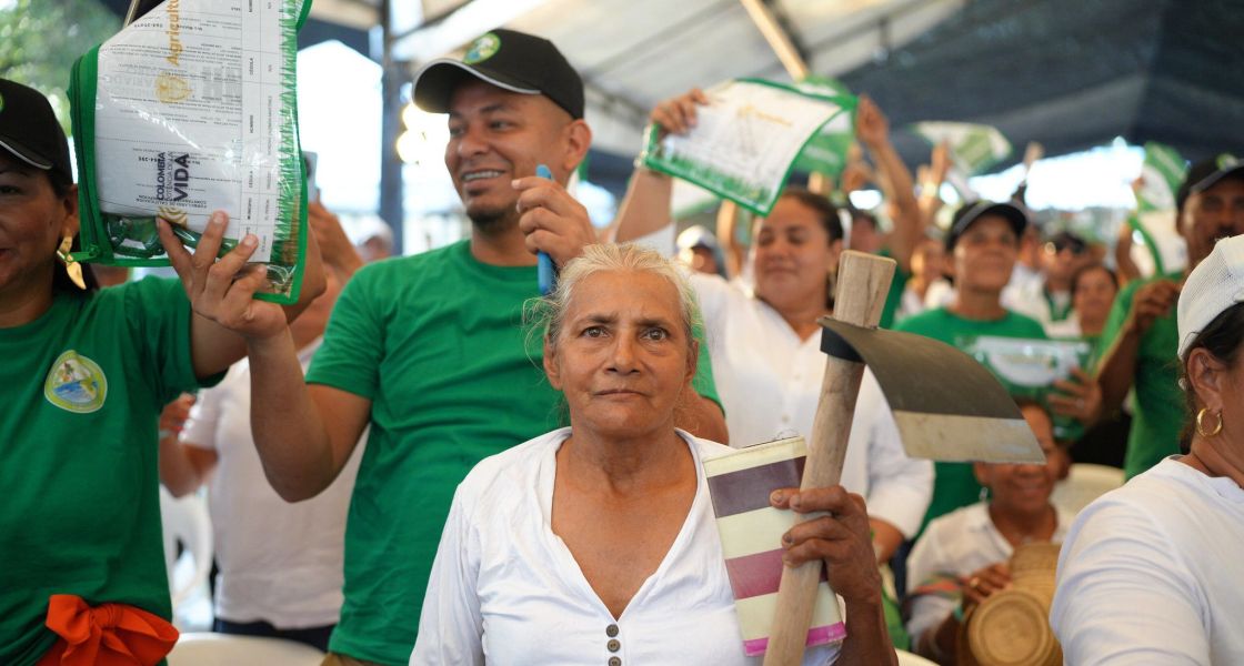 Die Kolumbianische Regierung vergibt im Rahmen der Agrarreform Landtitel an Campesinos, so wie hier im August 2024 Menschengruppe in grüner und weißer Kleidung mit Protestschildern