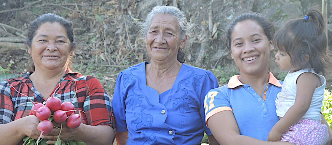 Drei Frauen, ein Kind auf dem Arm und ein Strauß Radieschen