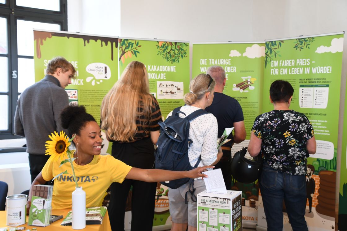 Besucher am Inkota-Stand auf der EuroBean Besucher betrachten Infotafeln einer Ausstellung.