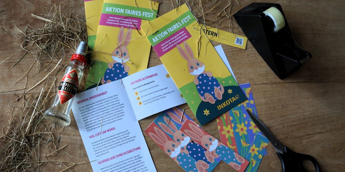 Faire Osterhasen-Riegel basteln auf einem Tisch liegen Bastelmaterialien und Flyer mit Osterhasen und Blumenmotiven