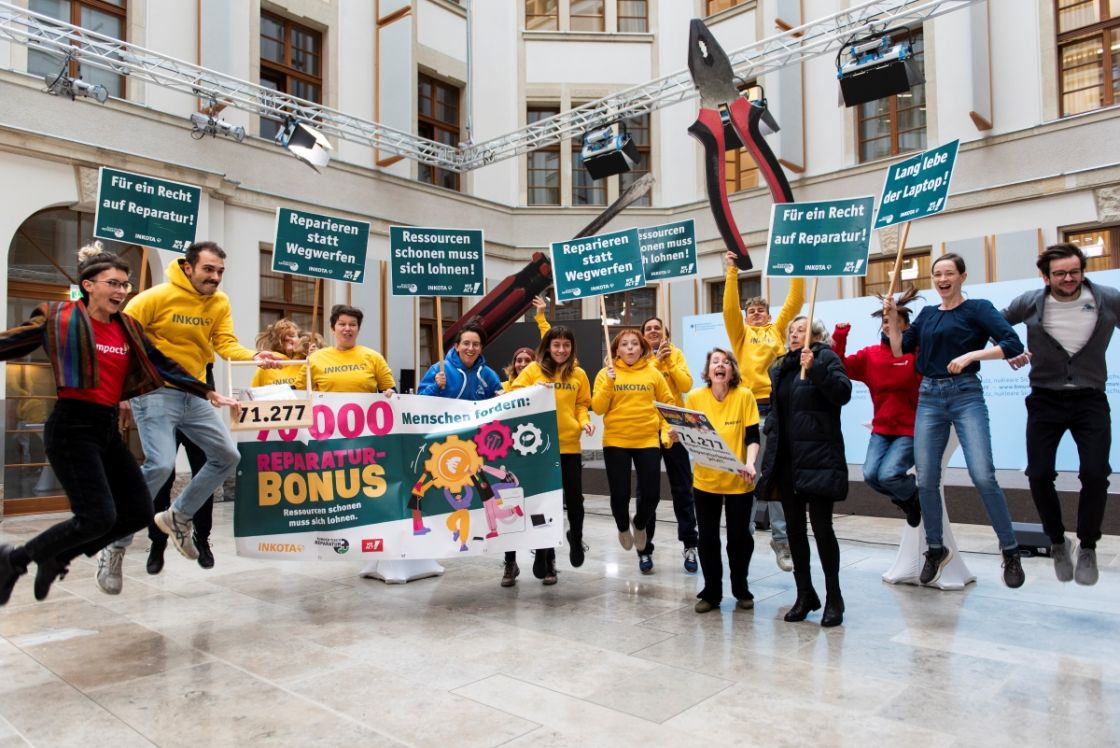 Eine Gruppe Menschen mit Schildern springt in die Luft