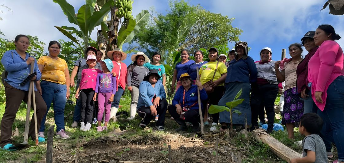 Gruppenfoto mit Projektteilnehmerinnen und Kindern aus El Salvador bei einer Baumpflanz-Aktion.