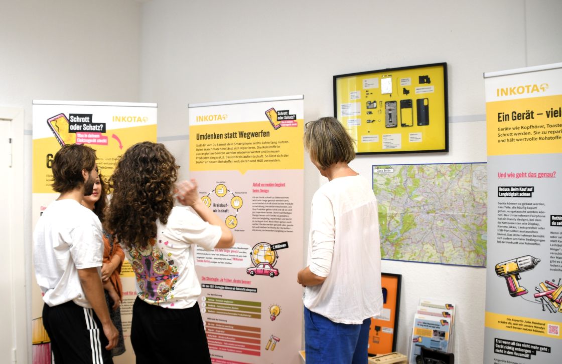 Foto der Ausstellung "Schrott oder Schatz" von Inkota mit Besuchenden im Vordergrund