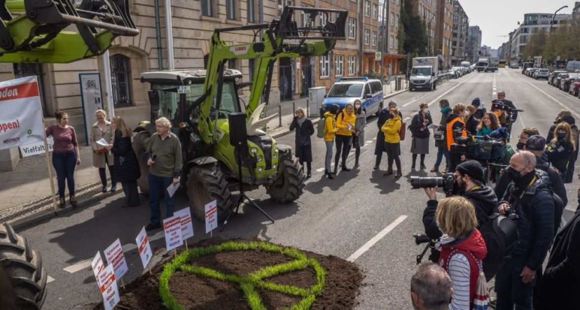 ein grüner Traktor und das Peace-Zeichen in Form von Graß in der Stadt
