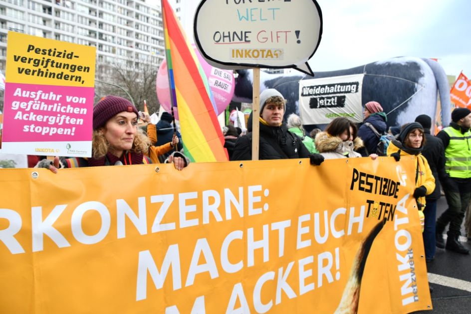 Menschen auf einer Demon halten Banner mit Aufschrift Agrarkonzerne macht euch vom Acker