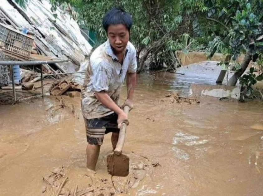 Ein Mann mit einer Schaufel in braunem Wasser