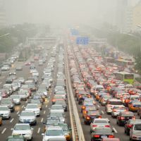 sehr breite Straße mit unzähligen Autos. Die Luft ist sehr neblig