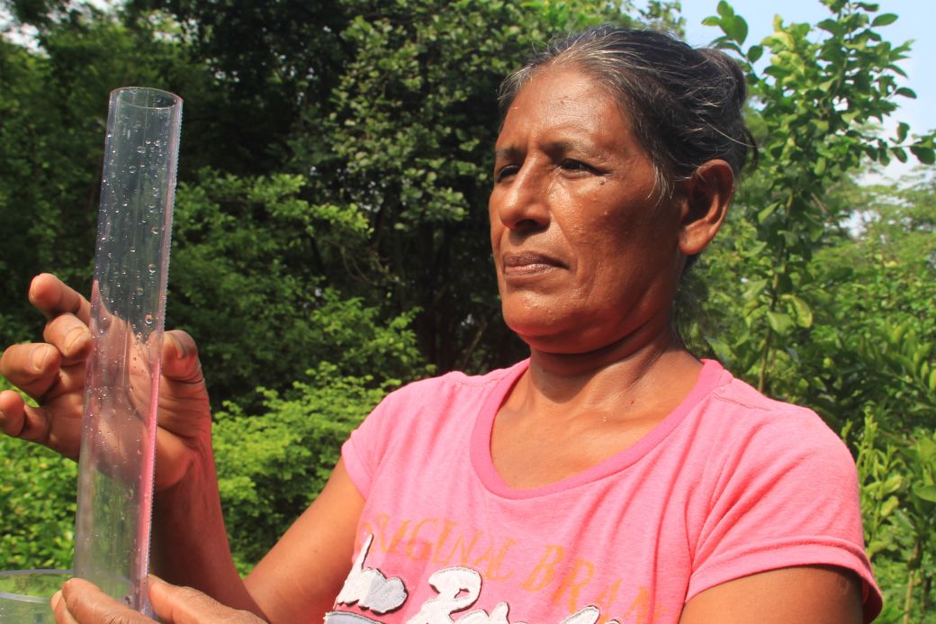 Eine Frau hält eine Regenwasser-Messtation in den Händen