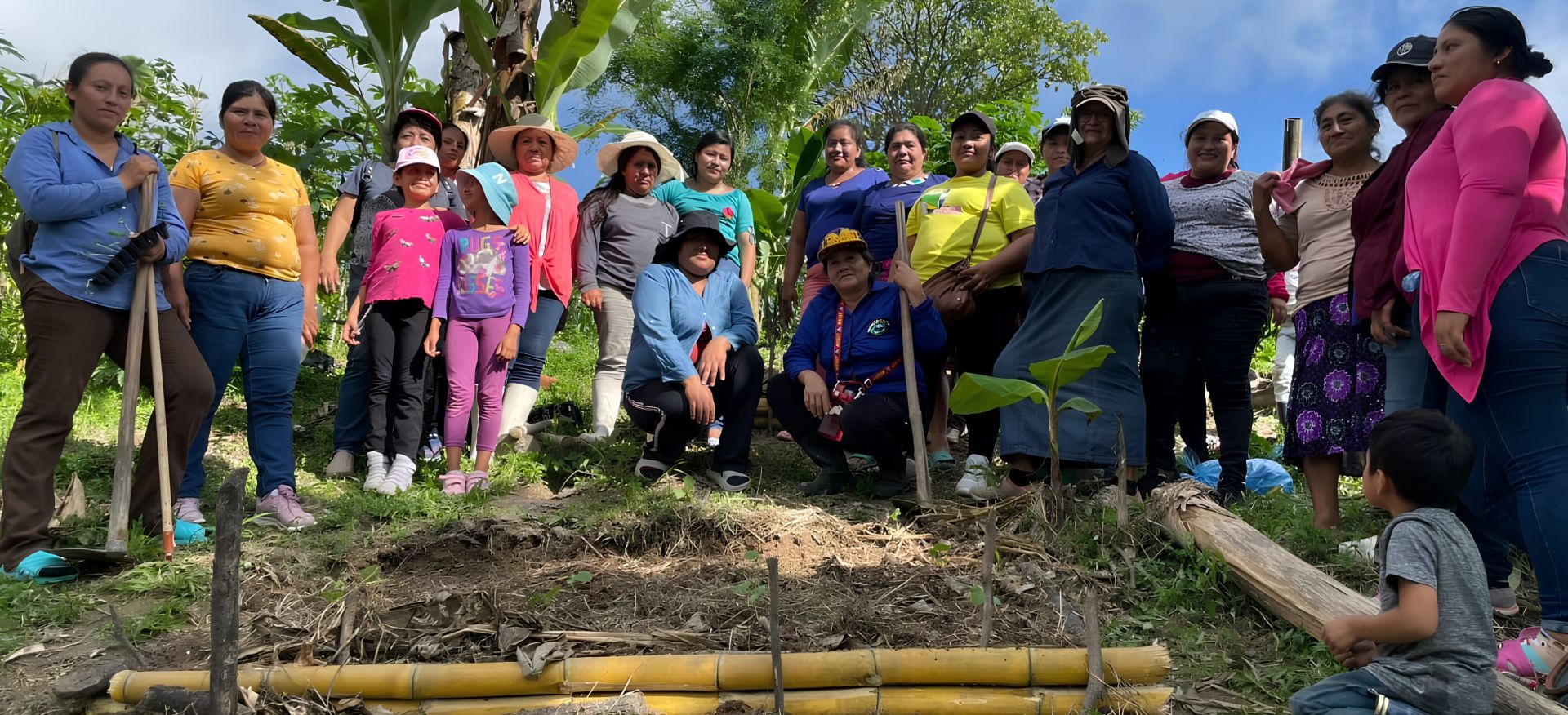 Gruppenfoto mit Projektteilnehmerinnen und Kindern aus El Salvador bei einer Baumpflanz-Aktion.
