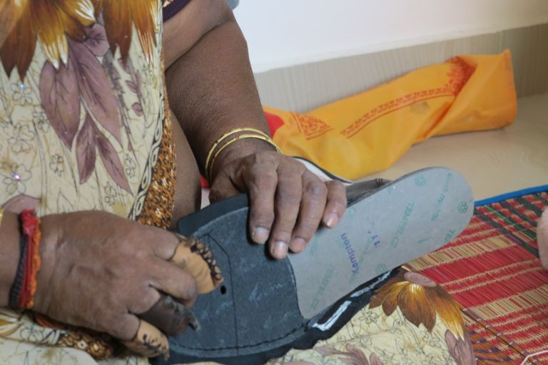 Indien: Heimarbeiterin fertigt Schuhe