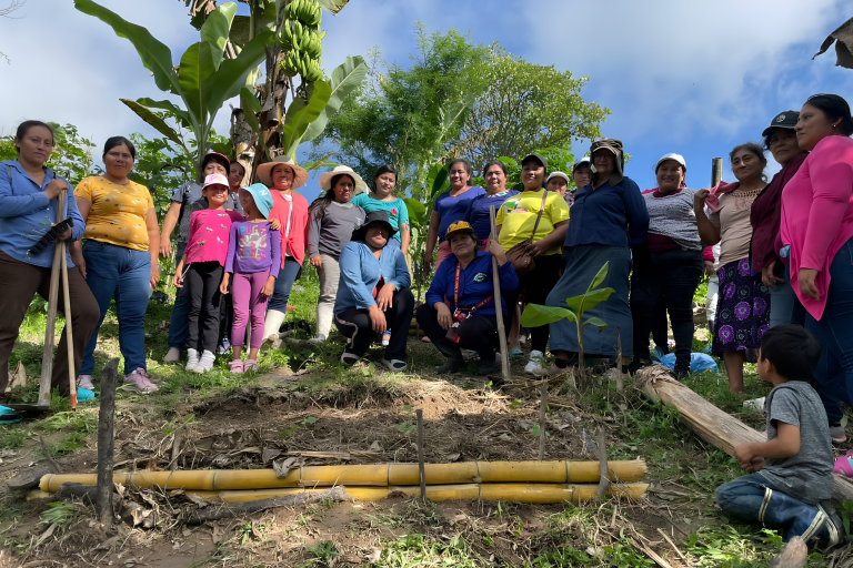 Gruppenfoto mit Projektteilnehmerinnen und Kindern aus El Salvador bei einer Baumpflanz-Aktion.