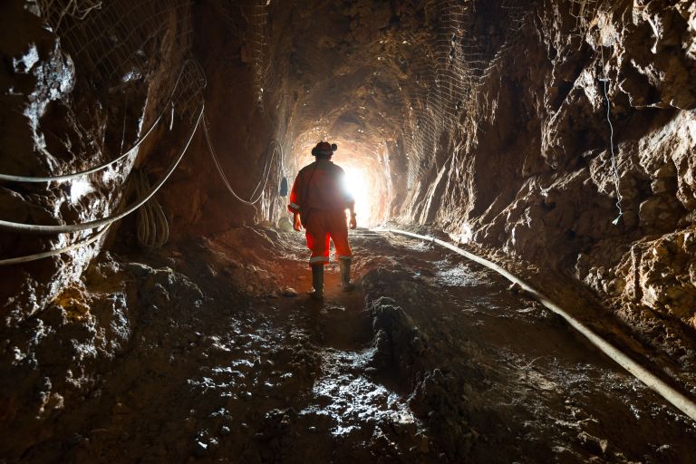 Bergbauarbeiter im Minenschacht im Gegenlicht fotografiert